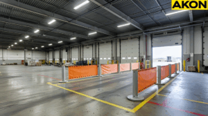 Orange retractable barriers creating a temporary safety zone in an industrial warehouse dock areas