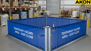 Portable retractable barriers forming a temporary hazard zone on a warehouse floors