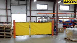 Yellow retractable barrier blocking a temporary warehouse staging zone near pallet storages